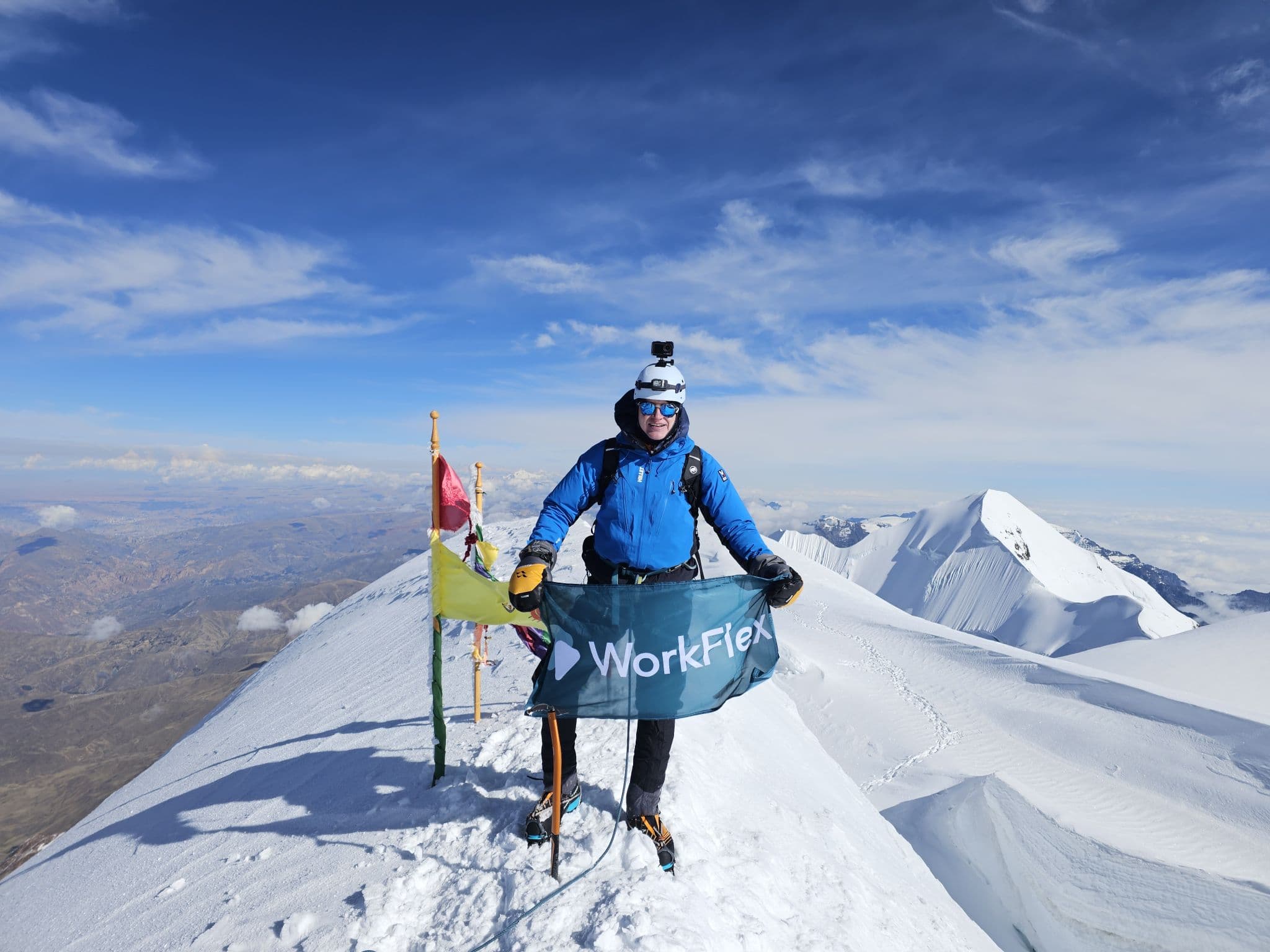 Max, our SOS lead, at the top of Illimani — 6,462m. He brought the flag himself.